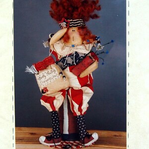 May include: A handmade patriotic doll named "Betty Boom" with red, white, and blue clothing and accessories. The doll is holding a bag that says "Betty Boom Fireworks, Inc!" and a firecracker. The doll is approximately 16 inches tall.