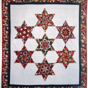 May include: A white quilt with a green border and a red and green patterned border. The quilt is made up of eight six-pointed stars, each with a different kaleidoscope-like design.