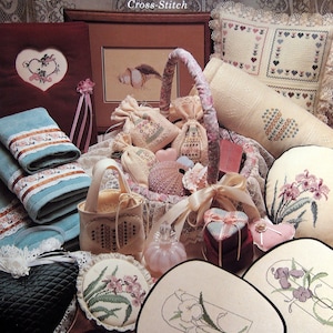 May include: A collection of cross-stitch patterns featuring lavender and old lace designs. The patterns include a pillow, a fan, a sachet, and a towel. The patterns are all in a vintage style and are perfect for adding a touch of elegance to your home.