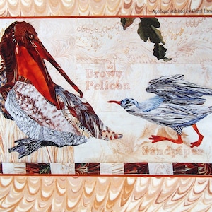 May include: A fabric art piece titled "Feather & Song" featuring a brown pelican and a sandpiper. The pelican has a large orange beak and the sandpiper has blue and white feathers. The artwork includes text that reads "Brown Pelican" and "Sandpiper".