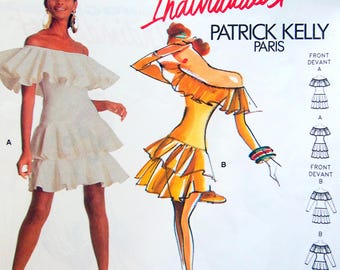 May include: A vintage Vogue Individualist pattern by Patrick Kelly. The image features a white off-the-shoulder dress with tiered ruffles and a sketch of a yellow dress with similar design elements. Text includes "Vogue Individualist" and "Patrick Kelly Paris".