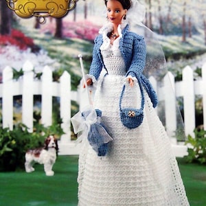 May include: A doll wearing a white crochet wedding dress, blue jacket, hat, and purse. The doll holds a white cane and a blue parasol. The image includes the text "The Southern Belle Collection Flower Show" in the upper left corner.