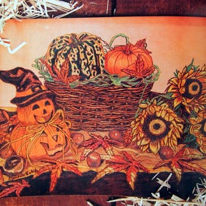 Puede incluir: Una pintura que representa una escena de cosecha de otoño con calabazas, calabacines, girasoles y hojas de otoño. Las calabazas están en una cesta tejida con una vid y hojas verdes. Los girasoles están en el fondo con tallos marrones y hojas verdes.