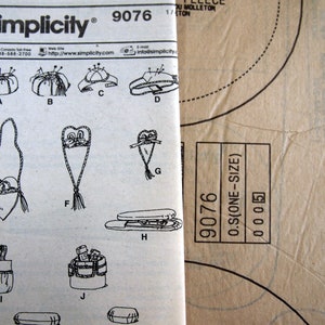May include: A Simplicity sewing pattern, number 9076, featuring various craft projects. The pattern includes illustrations of pincushions, bags, and other accessories. The pattern is printed on white paper with black text and illustrations. The pattern is one size.