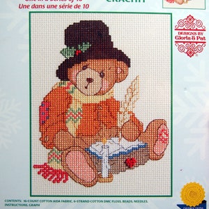 Peut inclure: Un modèle de point de croix compté représentant un ours en peluche brun portant un chapeau brun avec du houx et tenant une bougie. Le modèle est intitulé "Cherished Teddies: A Christmas Carol" et est de Priscilla Hillman. La taille finie est de 12,7 cm sur 17,8 cm.