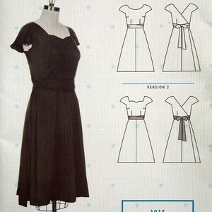 May include: A dark brown dress on a mannequin, with a scalloped neckline and short sleeves. The dress has a fitted waist and a flared skirt. Next to the dress are illustrations of dress patterns, labeled "Version 1" and "Version 2".