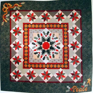 Peut inclure: Une courtepointe faite à la main avec un motif central de flocon de neige rouge, blanc et vert, entouré de blocs d'étoiles rouges et verts. La courtepointe a une bordure florale vert foncé et le mot "Peace" est brodé.
