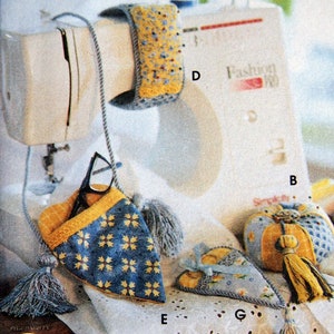 May include: An assortment of handmade fabric accessories, including a glasses case, pincushion, and wrist rest, all featuring blue and yellow floral patterns. Each item is adorned with tassels and decorative stitching.