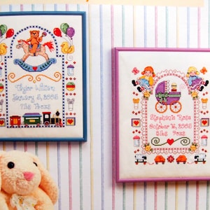 Puede incluir: Dos dise&ntilde;os de bordado de punto de cruz enmarcados. El primero es azul y presenta un osito de peluche montando un caballo de balanc&iacute;n con globos y un tren. El segundo dise&ntilde;o es rosa y presenta dos ni&ntilde;as sosteniendo un cochecito de beb&eacute; con un beb&eacute; dentro. Ambos dise&ntilde;os incluyen el nombre del beb&eacute;, la fecha de nacimiento y el peso.