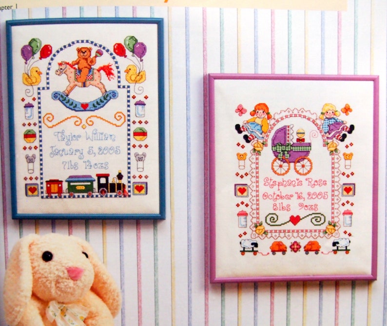 Puede incluir: Dos dise&ntilde;os de bordado de punto de cruz enmarcados. El primero es azul y presenta un osito de peluche montando un caballo de balanc&iacute;n con globos y un tren. El segundo dise&ntilde;o es rosa y presenta dos ni&ntilde;as sosteniendo un cochecito de beb&eacute; con un beb&eacute; dentro. Ambos dise&ntilde;os incluyen el nombre del beb&eacute;, la fecha de nacimiento y el peso.