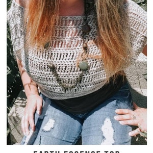May include: A crocheted top with an off-the-shoulder design. The top is made with a light brown yarn and has a loose, airy fit. The top is worn over a black tank top and paired with blue jeans. The text "EARTH ESSENCE TOP" and "crochet pattern" is visible at the bottom of the image. The website "serendipity-as-always.com" is also visible.