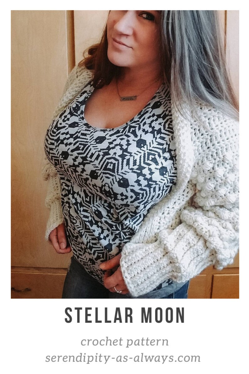 Op de afbeelding: Een wit gebreid vest met een textuurpatroon. Het vest wordt gedragen over een zwart-wit geprint shirt. De tekst "STELLAR MOON crochet pattern" en "serendipity-as-always.com" is zichtbaar onderaan de afbeelding.