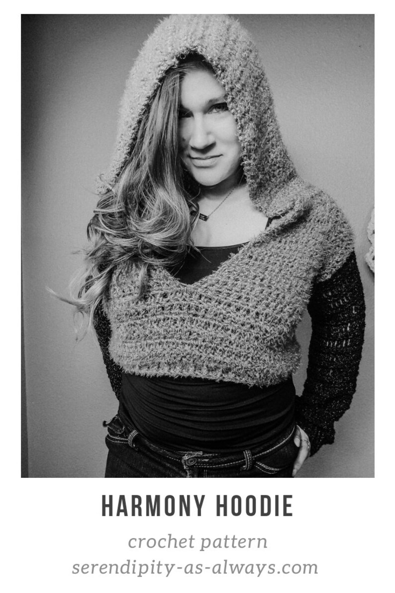 May include: A black and white photo of a person wearing a gray crocheted hoodie with a black crocheted sleeve. The hoodie has a V-neck and is cropped. The person is wearing jeans and has their hands in their pockets. The text "HARMONY HOODIE" is below the image, and the text "crochet pattern" and "serendipity-as-always.com" are below that.