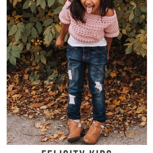 May include: A young girl wearing a pink crochet top with white crochet trim, blue jeans with distressed details, and brown ankle boots. The girl is standing in front of a leafy background and is sticking her tongue out.
