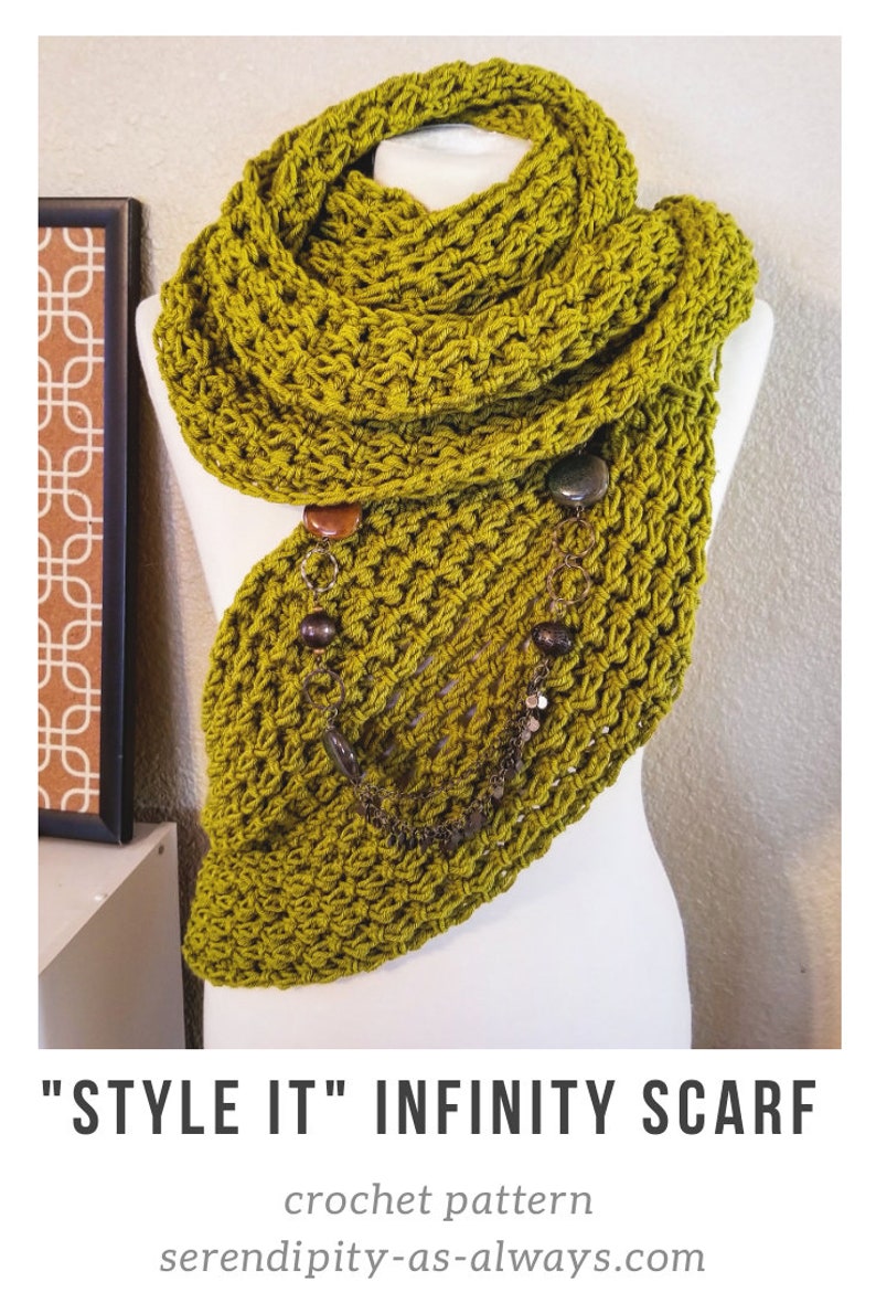 May include: A green crocheted infinity scarf with a chain and beads hanging from it. The scarf is draped over a white mannequin. "STYLE IT" INFINITY SCARF crochet pattern serendipity-as-always.com