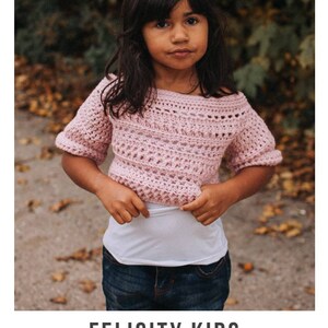 May include: A pink crochet top with a slightly off-the-shoulder neckline. The top has a delicate stitch pattern and short sleeves. The text "FELICITY KIDS crochet pattern" and "serendipity-as-always.com" is visible at the bottom of the image.