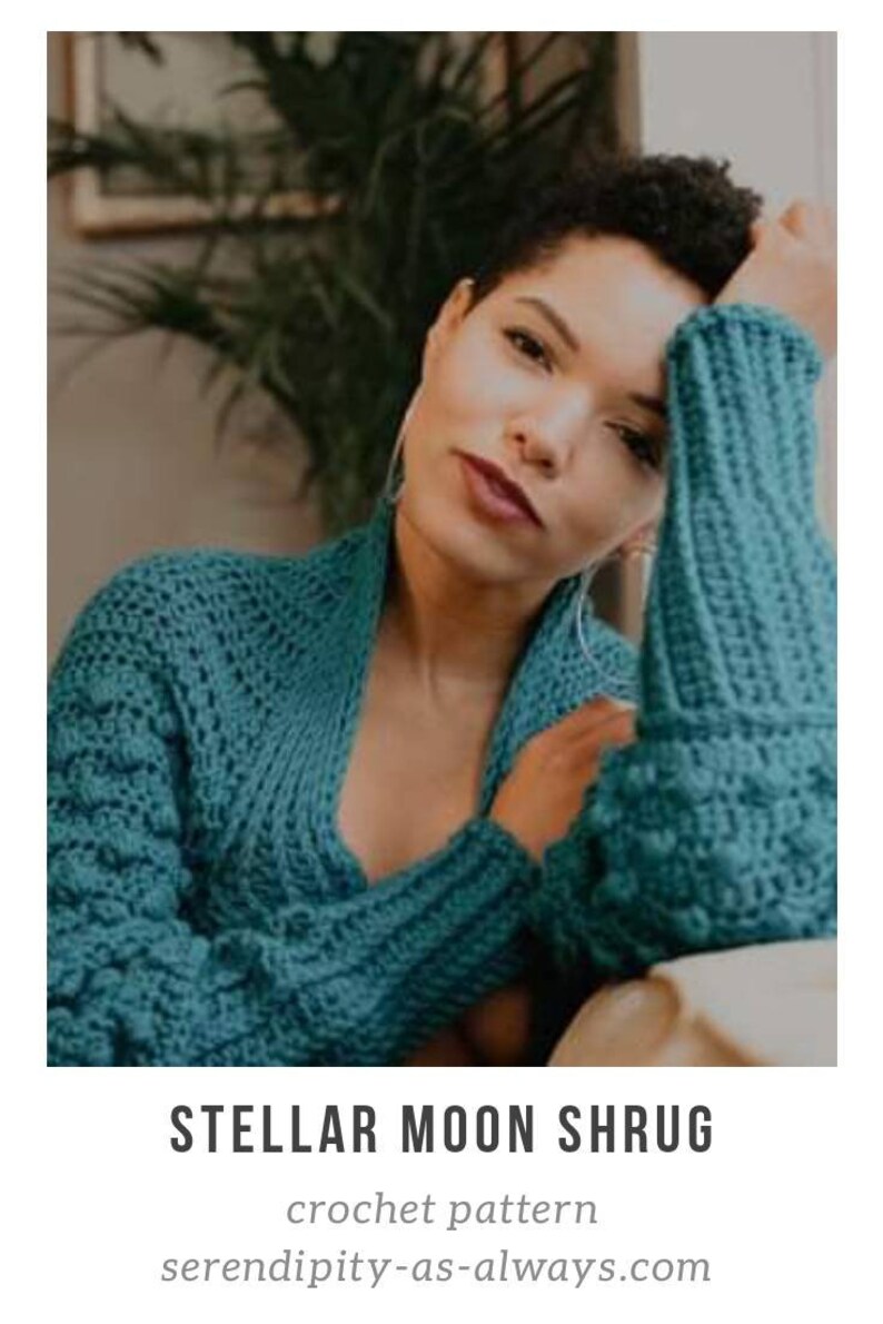 Op de afbeelding: Een tealblauwe gehaakte sjaal met een textuurpatroon. De sjaal wordt gedragen door een persoon met kort, krullend haar. De tekst "STELLAR MOON SHRUG" en "crochet pattern" is zichtbaar onder de afbeelding. Het websiteadres "serendipity-as-always.com" is ook zichtbaar.