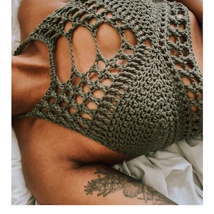 May include: A green crochet top with a large openwork design. The top is laying on a white surface. The text "GABRIELLE TOP" and "crochet pattern" are visible below the image. The website address "serendipity-as-always.com" is also visible.