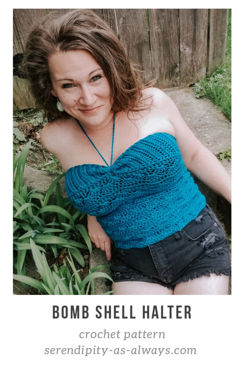 May include: A woman wearing a teal blue crochet halter top with a knotted front. The top has a delicate openwork design. She is wearing black denim shorts and is sitting on a stone step with green plants in the background.