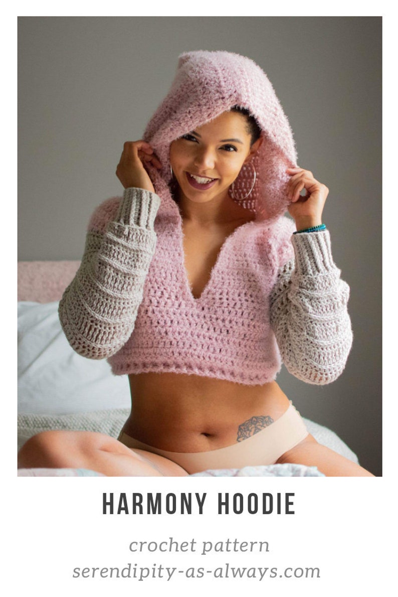 May include: A pink and grey crochet hoodie with a hood. The hoodie has a V-neck and is cropped. The text "HARMONY HOODIE" and "crochet pattern" are visible below the image. The text "serendipity-as-always.com" is visible below the text.
