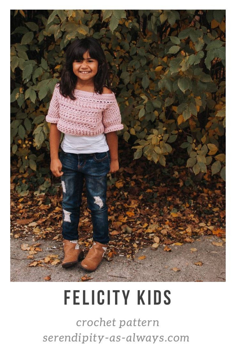 May include: A young girl wearing a pink crochet top with a white undershirt, blue jeans, and brown boots. The girl is standing in front of a bush with brown leaves on the ground. The image includes the text "FELICITY KIDS crochet pattern serendipity-as-always.com".