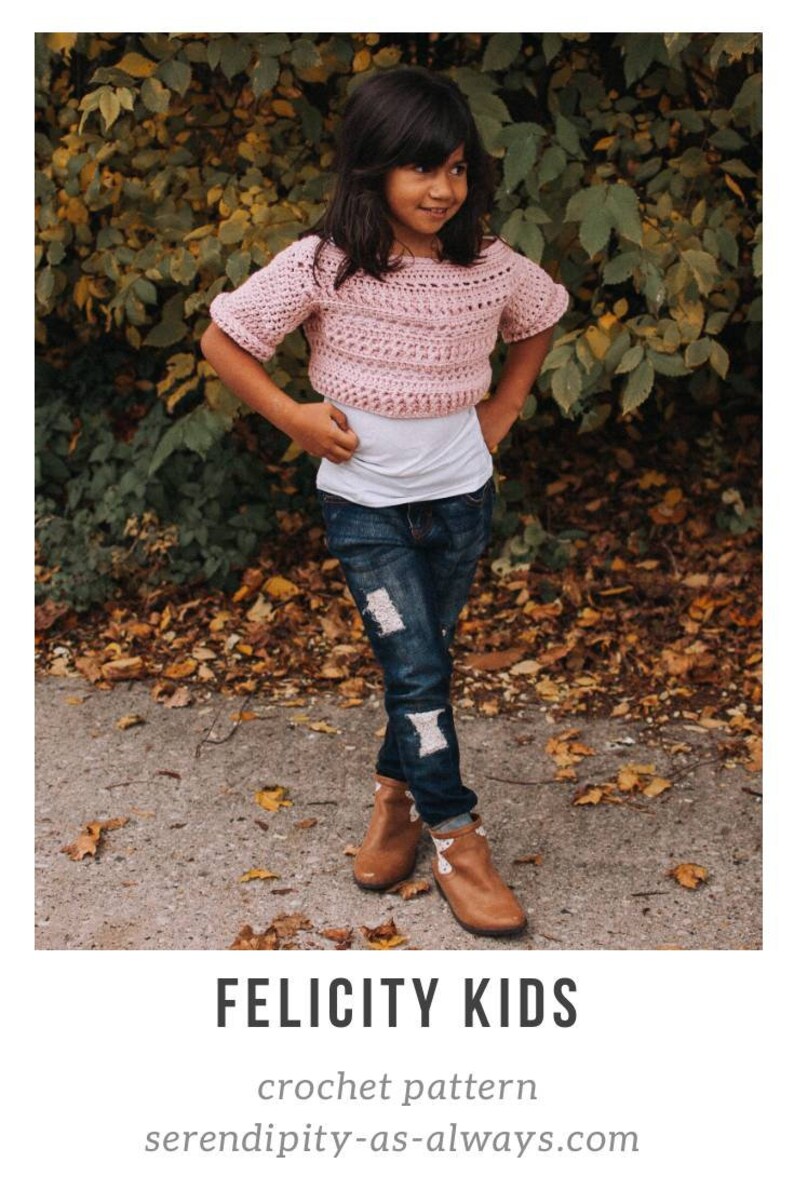 May include: A young person wearing a pink crochet top with short sleeves, blue jeans, and brown boots. The top is a cropped style and the jeans have distressed details. The person is standing in a wooded area with fallen leaves on the ground. The text "FELICITY KIDS crochet pattern" and "serendipity-as-always.com" is visible at the bottom of the image.