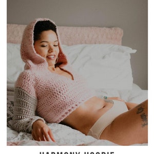 May include: A pink crochet hoodie with a gray stripe on the sleeve. The model is wearing the hoodie and smiling. The text "HARMONY HOODIE" and "crochet pattern" are visible below the image. The website address "serendipity-as-always.com" is also visible.