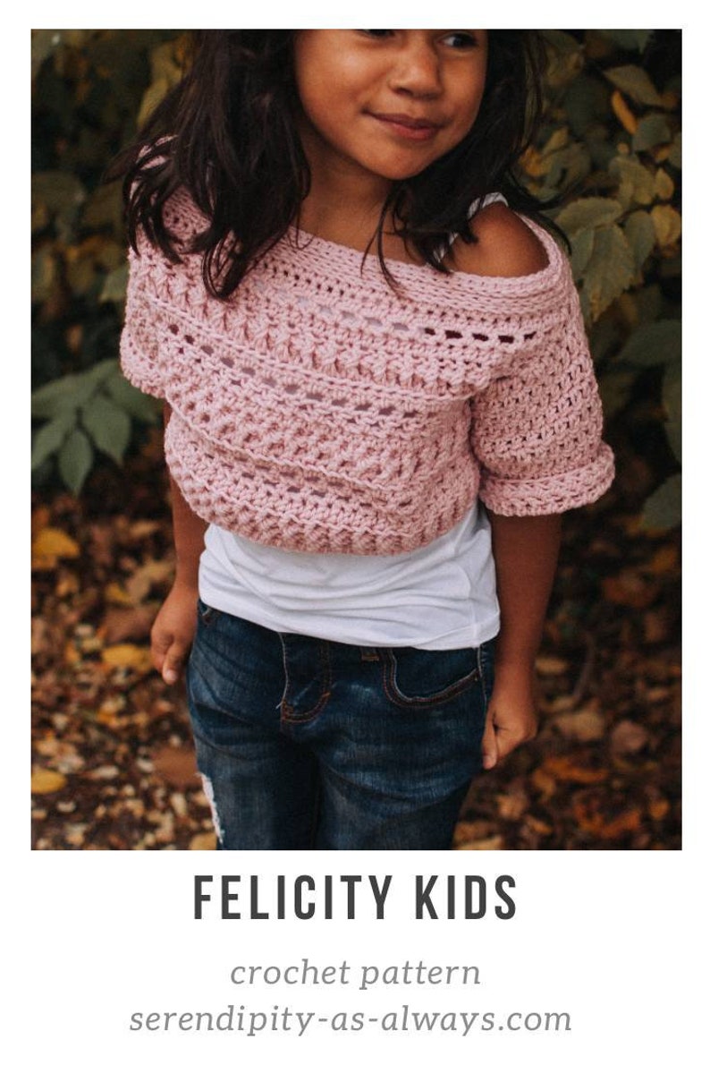 May include: A pink crochet top with a slightly off-the-shoulder design. The top has a simple stitch pattern and short sleeves. The model is wearing the top with a white t-shirt underneath and blue jeans. Felicity Kids crochet pattern serendipity-as-always.com