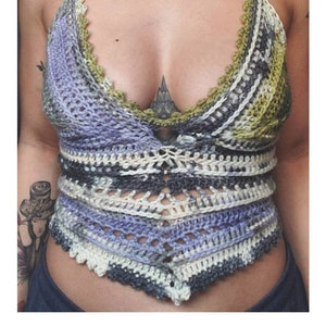 May include: A handmade crochet halter top in shades of blue, green, and white. The top features a scalloped edge and a geometric design. The word "CALLISTO" is displayed below the top.