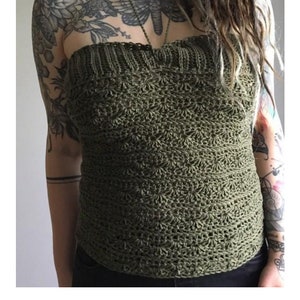 May include: A green crochet halter top with a shell stitch pattern. The top is shown on a model with tattoos. The text "BOMB SHELL HALTER crochet pattern serendipity-as-always.com" is at the bottom of the image.