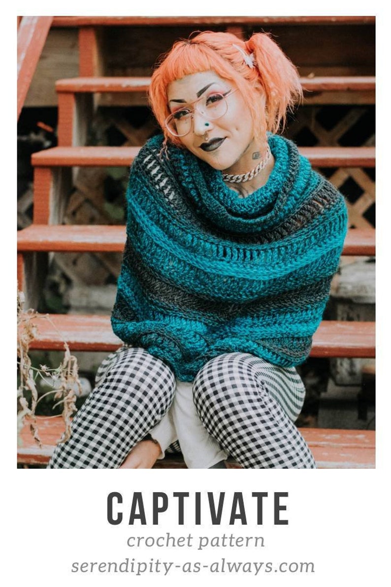 May include: A teal and gray crochet shawl with a cowl neck. The shawl is worn by a person with pink hair and glasses. The person is sitting on wooden steps.