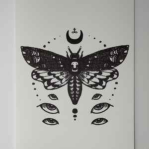 Puede incluir: Ilustraci&oacute;n en blanco y negro de una polilla con una cara de calavera, rodeada de ojos y una luna creciente con un s&iacute;mbolo arriba.