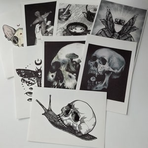 Puede incluir: Un conjunto de ilustraciones en blanco y negro que presentan una variedad de im&aacute;genes macabras, incluyendo un cr&aacute;neo, una polilla, un caracol y una mano humana sosteniendo una mu&ntilde;eca. Las ilustraciones est&aacute;n impresas en cartulina blanca y son perfectas para agregar un toque de estilo g&oacute;tico a cualquier espacio.