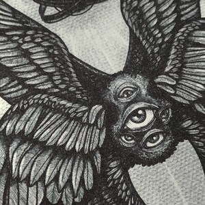 May include: Detailed black and white illustration of a multi-eyed creature with large feathered wings. A sphere with intersecting rings floats above the creature. The artwork has a detailed, textured appearance.