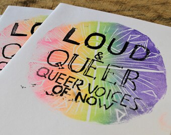 Könnte beinhalten: Drei weiße Taschenbücher mit einem Regenbogenkreis-Design und dem Text "Loud & Queer Queer Voices of Now" auf dem Cover.