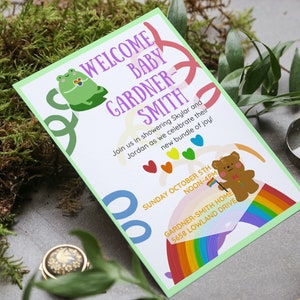May include: A green and purple baby shower invitation with a frog, a rainbow, and a teddy bear holding a rainbow flag. The text reads "Welcome Baby Gardner-Smith". Join us in showering Skylar and Jordan as we celebrate their new bundle of joy! Sunday October 5th Noon-4pm Gardner-Smith Home 5658 Lowland Drive