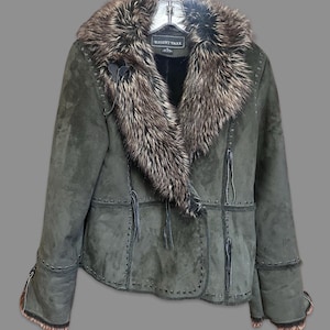 May include: A dark green suede jacket with a faux fur collar. The jacket features decorative stitching, a button closure, and fringe detailing. The label reads "REGENT PARK".