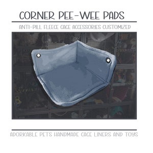 May include: A blue corner pee-wee pad for small pets. The pad is made of anti-pill fleece and is designed to fit in the corner of a cage. "CORNER PEE-WEE PADS ANTI-PILL FLEECE CAGE ACCESSORIES CUSTOMIZED ADORKABLE PETS HANDMADE CAGE LINERS AND TOYS" is written on the image.