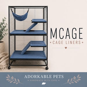 Op de afbeelding: Een zwarte metalen dierenkooi met blauwe stoffen voeringen op de plateaus en de bodem, een blauwe stoffen hangmat opgehangen aan de bovenkant en blauwe hellingen tussen de niveaus. De tekst luidt MCAGE CAGE LINERS en ADORKABLE PETS HANDMADE WITH CARE.