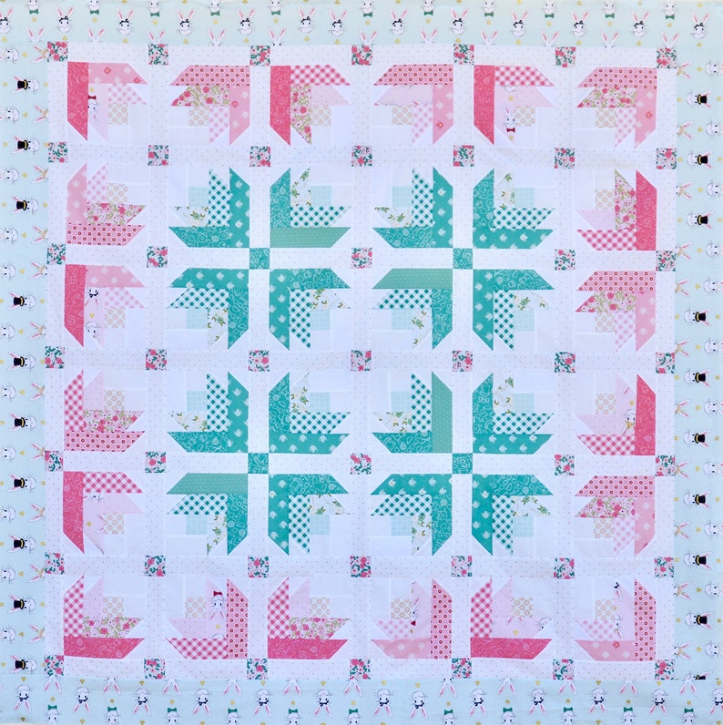 K&ouml;nnte beinhalten: Eine Steppdecke mit wei&szlig;em Hintergrund und einem Muster aus rosa und t&uuml;rkisfarbenen Quadraten. Die Quadrate sind in einem sich wiederholenden Muster aus vier Quadraten angeordnet, wobei jedes Quadrat ein anderes Design enth&auml;lt. Die Steppdecke ist mit einem Rand aus wei&szlig;em und t&uuml;rkisfarbenem Stoff eingefasst.