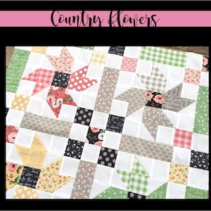 May include: A quilt block featuring a country flower theme. The block is made up of various fabrics with floral patterns, gingham, polka dots, and text. The block is white with a grey, black, and yellow border.
