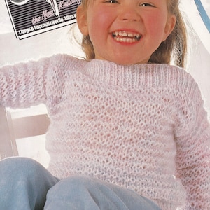 May include: A young girl wearing a light pink knitted sweater with a textured open weave. The sweater has long sleeves and a round neckline. The image includes text that reads "Odpir" and "the New Knitting". The sweater is designed for a 51-76 cm chest.