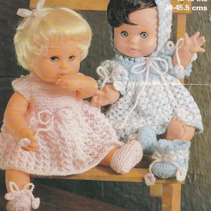 May include: Two vintage dolls dressed in handmade knitted outfits. One doll wears a pink dress and matching booties, the other a blue hooded dress and booties. The image includes text that reads "4 ply 12-18 ins 30-45.5 cms".