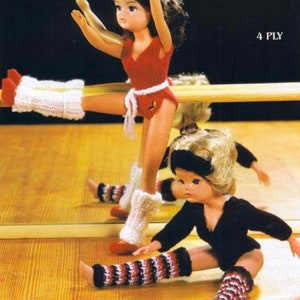 May include: Two dolls wearing knitted leg warmers. One doll is wearing a red leotard and white leg warmers. The other doll is wearing a black leotard and striped leg warmers. The text "4 PLY" is visible in the upper right corner of the image.