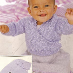 Puede incluir: Un cárdigan de punto para bebé de color lavanda con un estilo envolvente y un cierre de botón único. El cárdigan se muestra en un bebé que lleva una falda lavanda a juego.