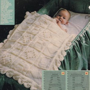 May include: Cream-colored knitted baby blanket with a textured block pattern and diamond motifs. The blanket has a scalloped edge and is draped over a baby in a green crib. The text reads, "Make the newest arrival an heirloom to treasure."