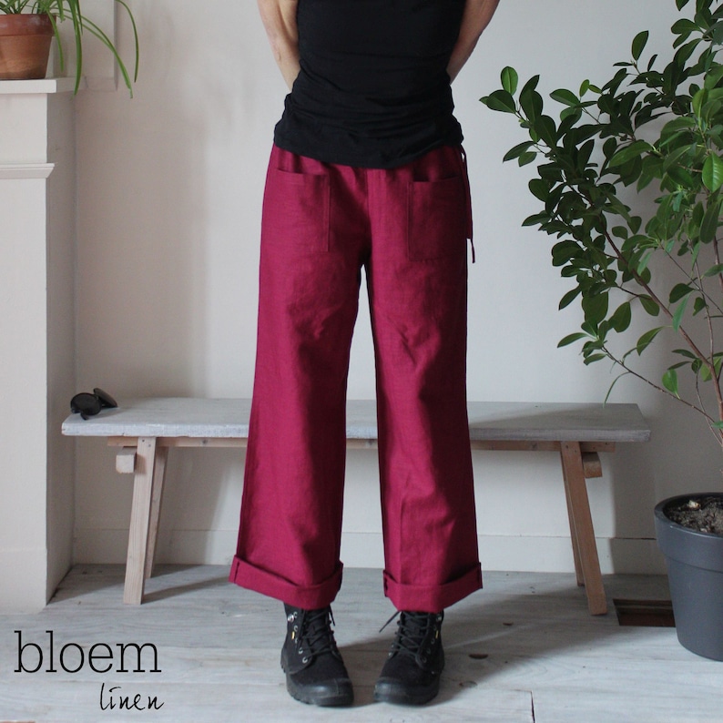 Puede incluir: Un pantal&oacute;n de lino ancho de color burdeos con dobladillo. El pantal&oacute;n tiene dos bolsillos grandes en la parte posterior.