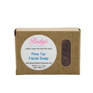 May include: A brown cardboard box with a white label that says "Becky's Tallow Treasures" and "Pine Tar Facial Soap". The label also includes the website address "www.BeckysTallowTreasures.com", the net weight of 113 g, and the location "Apple Valley, CA".