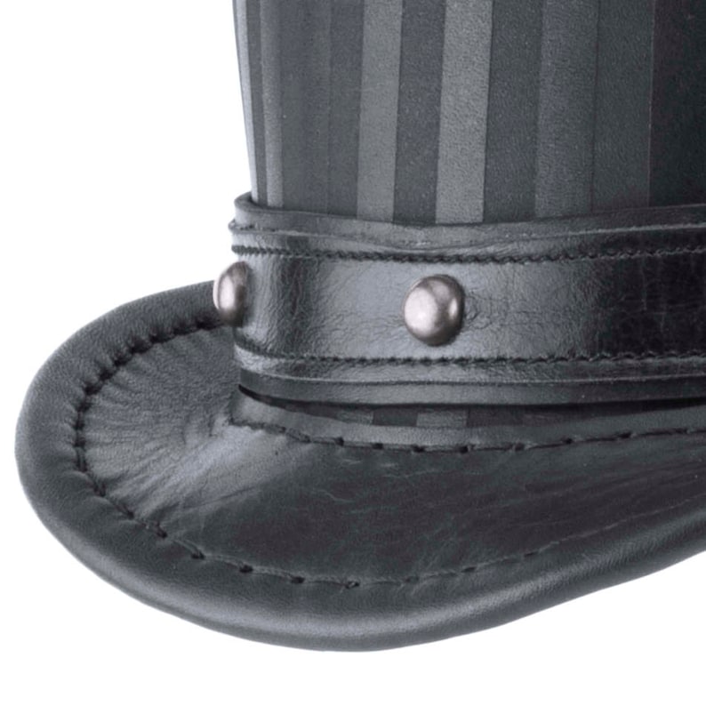 May include: A black leather top hat with a striped fabric crown and a leather band with silver studs.