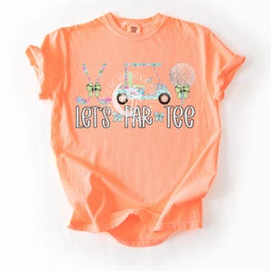 May include: Orange short-sleeved t-shirt with a golf cart, golf clubs, golf balls, and bows in a floral pattern. The text "Let's Par-Tee" is printed in white glitter on the shirt.